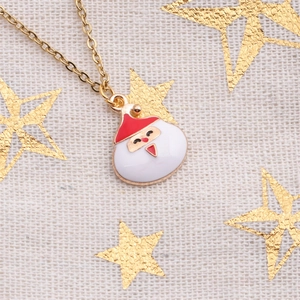 Collier de Noël avec pendentif Père Noël en émail et chaîne dorée sur lin beige
