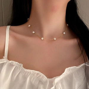 Elegant French-style gold chain pearl necklace with flower heart design on a female model