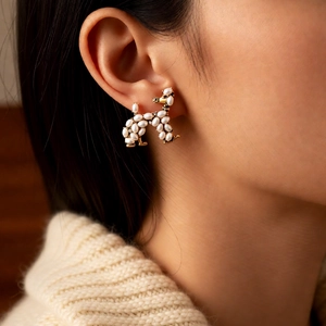 Close-up of vintage-style poodle earring with white pearls and sparkling diamond accents