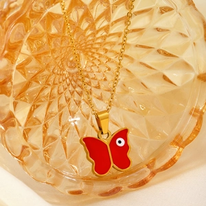 Goldene Halskette mit rotem Schmetterling-Anhänger und bösem Blick auf Bernstein-Glas