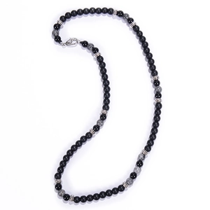 Detail of vintage necklace with black matte beads and grey marble stones on white background