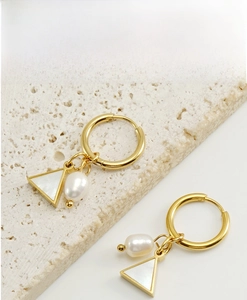 Detail of 18K gold earrings featuring triangle shell and teardrop pearl charms