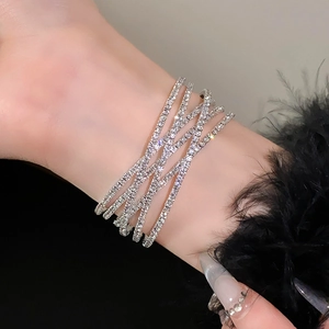 Macro-opname van zilveren gelaagde strass-wikkelarmband om pols met veren accenten
