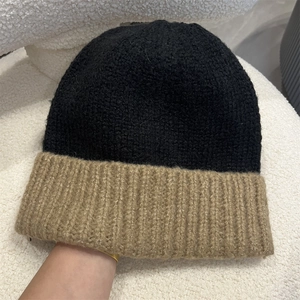 Close-up of thick ribbed knit texture on a dual-tone black and brown beanie hat