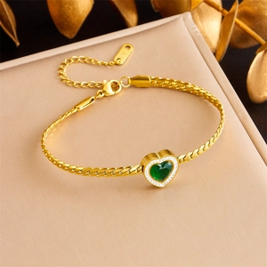 Détail du bracelet en acier doré avec pierre cœur verte et cristaux étincelants