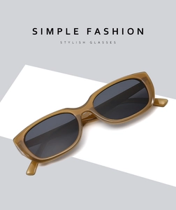 Detail einer bernsteinfarbenen Sonnenbrille mit dunklen Gläsern auf minimalistischem Grund