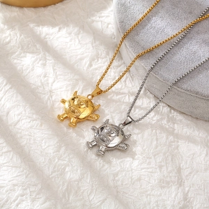 Close-up of hip-hop monster pendants in gold and silver finish with metal box chains