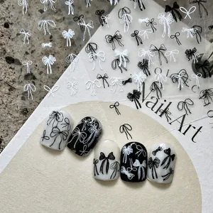 Detail of hand-drawn black and white bow nail art stickers on display tips