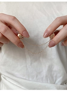 Detailed view of rose gold magnetic chain clip used for shortening T-shirt hems