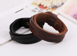 Close-up of black and brown multi-layer braided leather bracelets with metal buckles