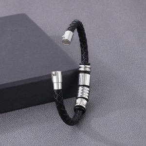 Close-up of black braided leather bracelet with magnetic stainless steel clasp on texture
