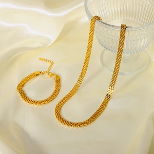 Golden 18K plated stainless steel woven necklace and bracelet set on cream silk