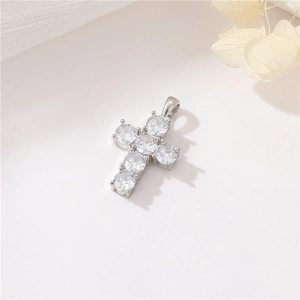 Macro shot of a silver cross pendant with shimmering zircon stones and top hanging ring