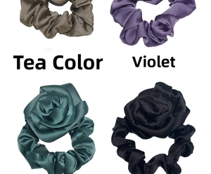 Detailed view of satin floral hair scrunchies in brown, violet, green, and black