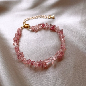 Vue détaillée du bracelet en pierre naturelle rose avec fermoir doré sur tissu de soie