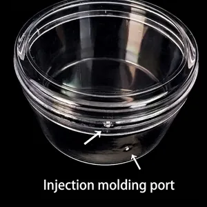 Clear round plastic storage box with lid showing detailed injection port markings