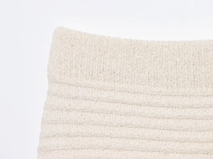 Detailed macro view of the cream knit texture and thickened hem on the skirt set