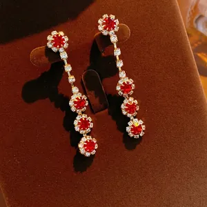 Vintage gold tassel earrings with red floral gemstones and sparkling diamond accents