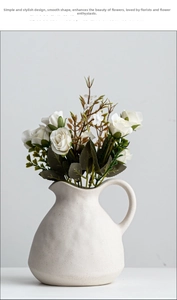 Detail of matte white ceramic vase with speckled texture and elegant curved handle