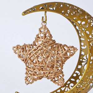 Détail de la lune en fer doré avec un pendentif étoile tressé pour décoration de fête