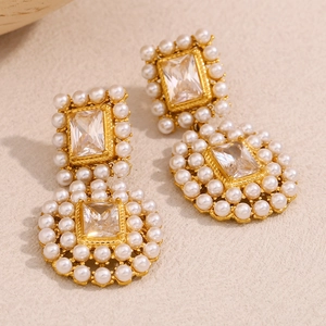 Detailed macro of vintage pearl drop earrings with 18K gold plating and cubic zirconia