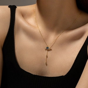 Elegant gold Y-necklace featuring a blue pear-cut stone and white marquise accents