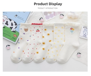 Close-up of cute bear embroidery and frilled edges on white cotton mid-calf socks
