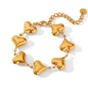 Detailed macro view of heart-shaped links on gold stainless steel bracelet with clasp