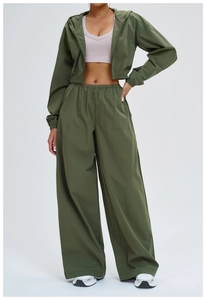 Detail of dark green hooded windproof jacket and wide-leg sports pants set with texture