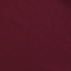 Gros plan sur la texture en maille rouge vin foncé d'une robe asymétrique chic