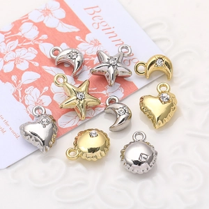 Detailed close-up of mini gold and silver alloy charms featuring stars, moons and hearts