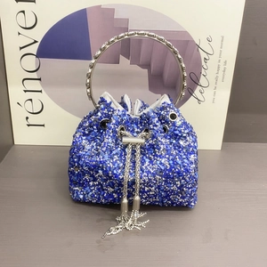 Detail of blue bucket bag with sparkling crystals, silver round handle, and metal tassels