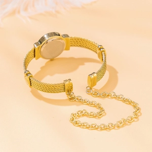 Detail of gold bracelet watch with rope texture band and chain on beige background