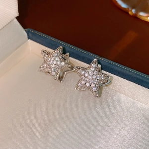 Macro shot of silver star earrings with cubic zirconia inlay in a jewelry box