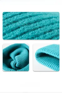 Detail view of the chunky knit texture and soft fabric of the turquoise beanie hat