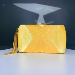 Detail of satin evening clutch featuring cross-overlap texture and golden tassels
