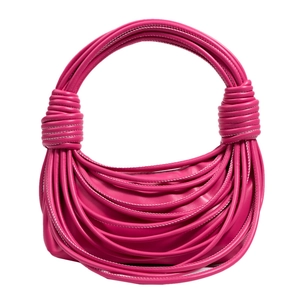 Dettaglio macro della trama in corda intrecciata rosso rosa e manico annodato della borsa
