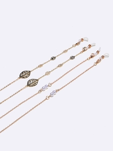 Lot de 4 chaînes de lunettes dorées avec feuilles en métal et perles sur fond blanc