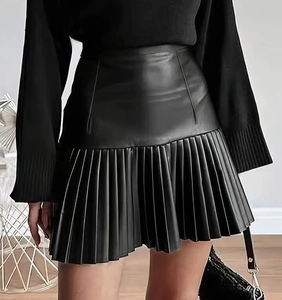 Detail eines schwarzen Mini-Faltenrocks aus Kunstleder mit hoher Taille und Glanz