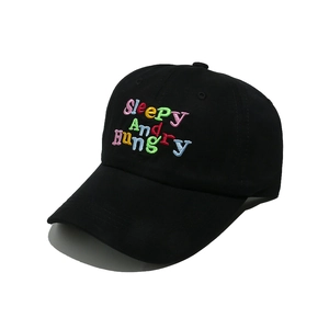 Gros plan détaillé de la broderie colorée 'Sleepy And Hungry' sur la casquette noire