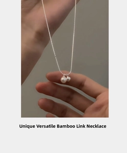Detail of s925 silver bamboo chain necklace featuring two pendants with a white freshwater pearl