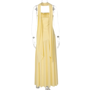 Detail of elegant yellow tube dress featuring long decorative ribbons and pleated hemline