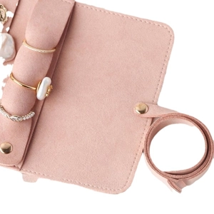 Pink microfiber jewelry roll organizer featuring dedicated slots for rings and bracelets