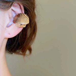 Detailed close-up of shell-shaped rose gold ear cuff with elegant textured surface