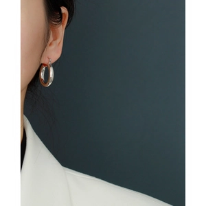 Close-up of minimalist S925 sterling silver hoop earring worn on a model's ear