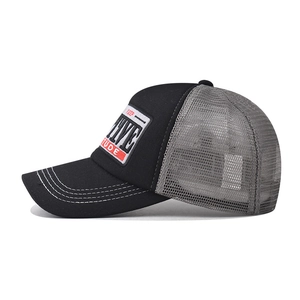 Detail of 3D POSITIVE embroidery on a black and grey mesh trucker baseball cap