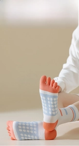 Detail of five-finger sports socks with orange blue patchwork and anti-slip dot grips