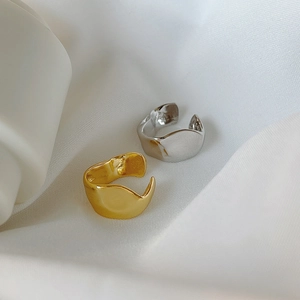 Detail of minimalist irregular lava rings in gold and silver on white silk
