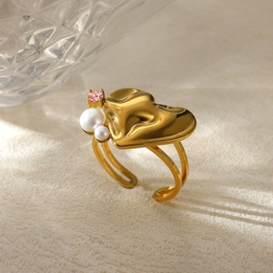 Detail of adjustable gold heart ring featuring delicate white pearls and pink gemstone