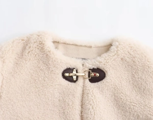 Détail du col en polaire blanc cassé avec base en cuir et fermoir en métal doré